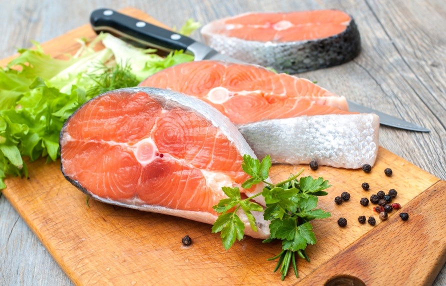 Salmon fillets in slices on a cutting board. Salmon fillets in slices on a cutting board.